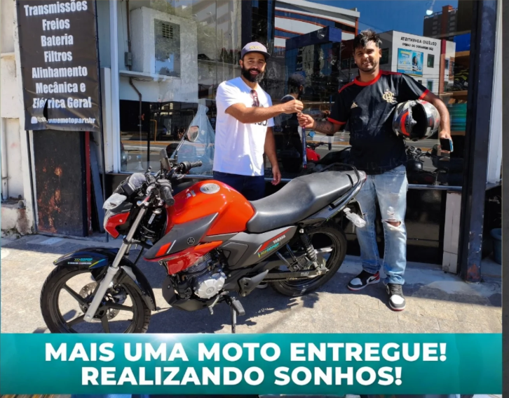 Cliente recebendo a chave da moto GO POP na loja